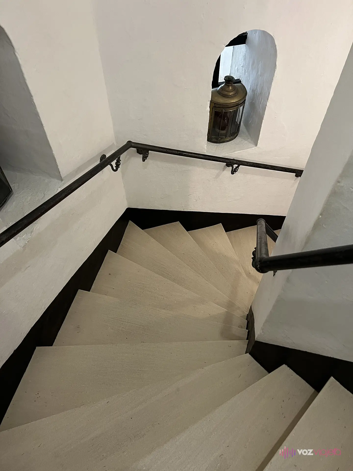 La escalera de caracol que sube por el interior de la Torre del Oro, con un farol de barco antiguo en una hornacina