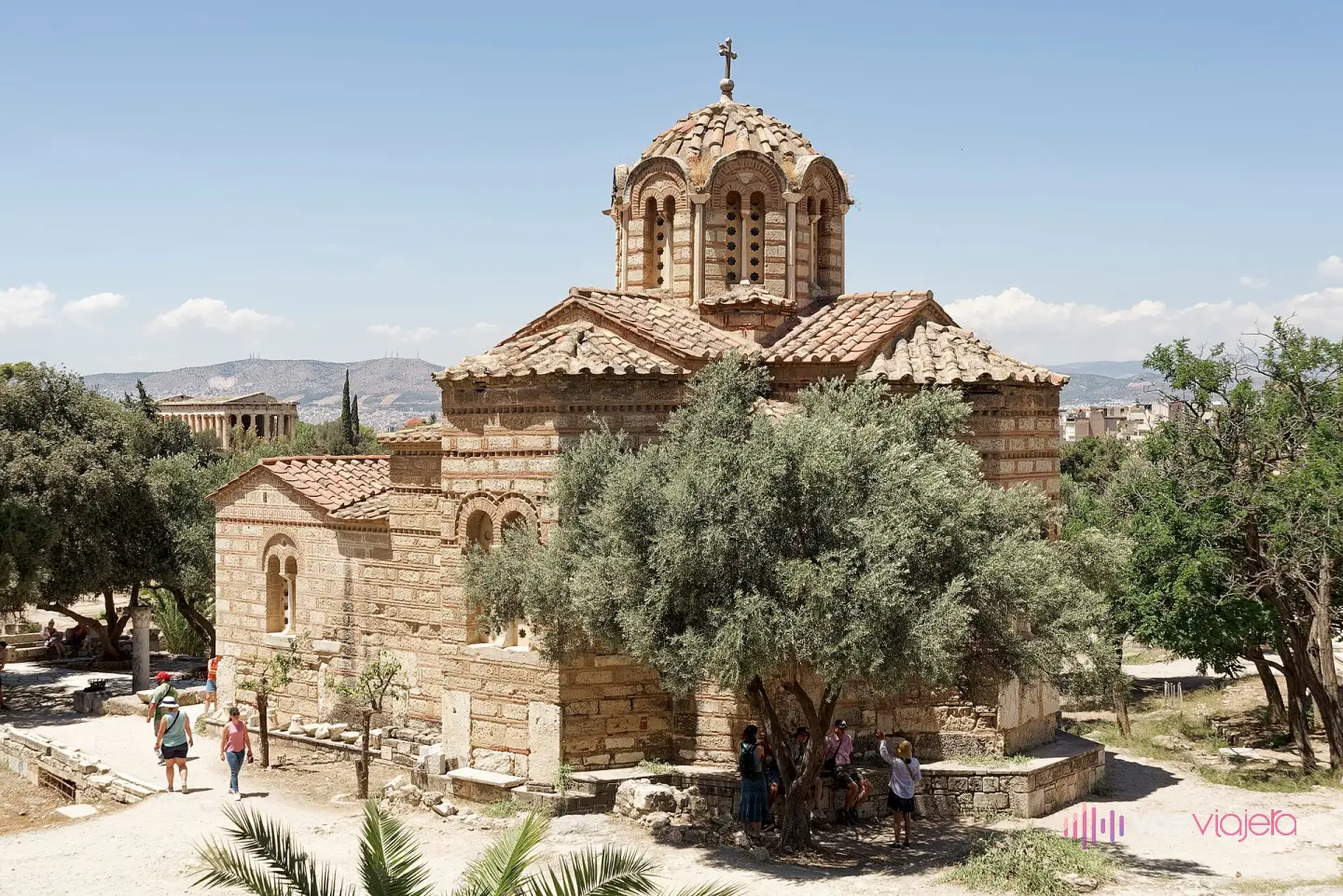 La iglesia bizantina de los Santos Apóstoles en el Ágora de Atenas, con su cúpula sobre tambor y su fábrica de piedra y ladrillo; al fondo, a la izquierda, el Templo de Hefesto