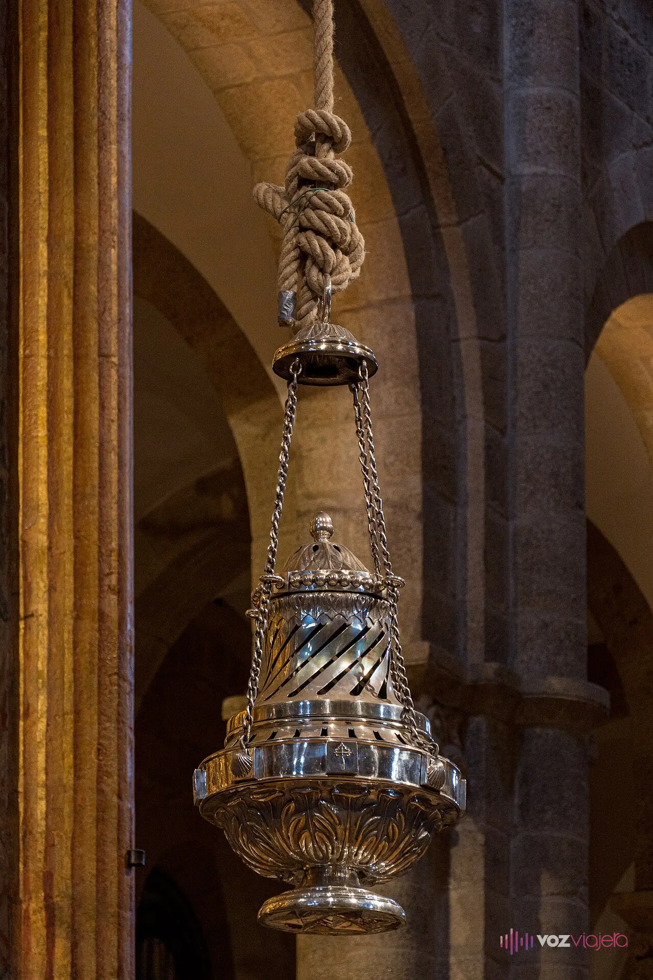 El botafumeiro de la catedral de Santiago, un gran incensario plateado colgado de una gruesa cuerda entre columnas de granito