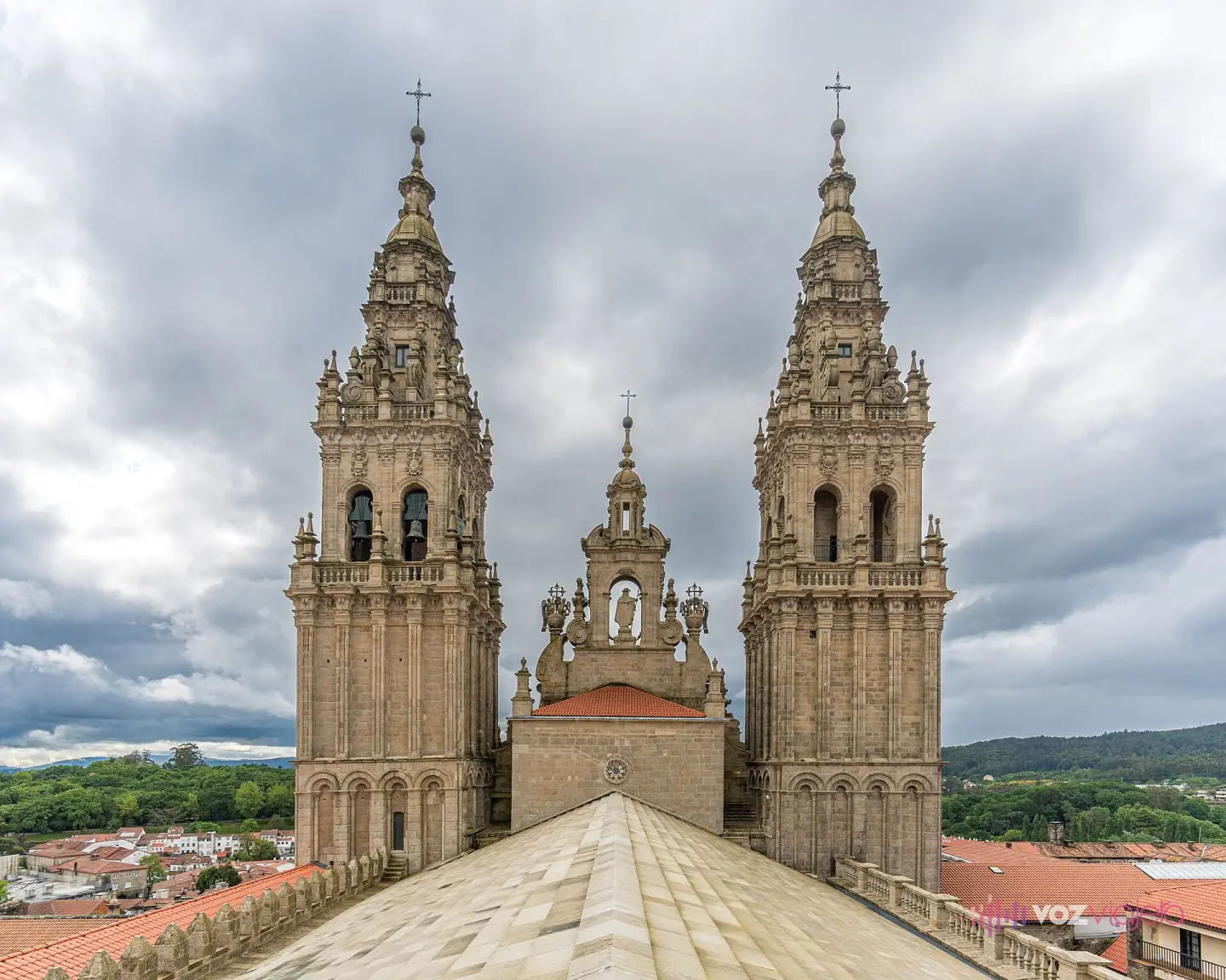 Las cubiertas escalonadas de granito de la catedral de Santiago con las dos torres de la fachada del Obradoiro al fondo, bajo un cielo nublado