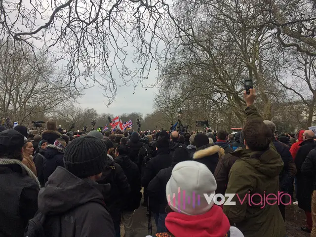 Un corrillo de gente abrigada escuchando a un orador en Speakers' Corner, en la esquina noreste de Hyde Park, entre árboles sin hojas