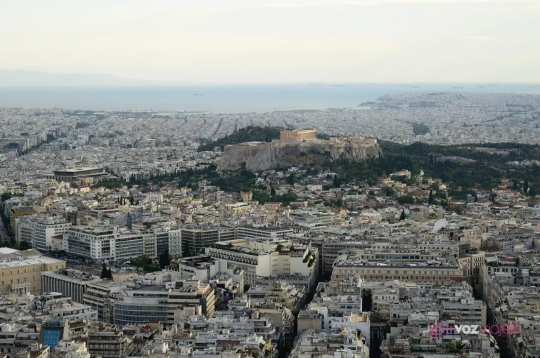 Panorámica de Atenas desde la cima del monte Licabeto: el mar de azoteas blancas del centro, la roca de la Acrópolis con el Partenón encima y, al fondo, la costa del golfo Sarónico
