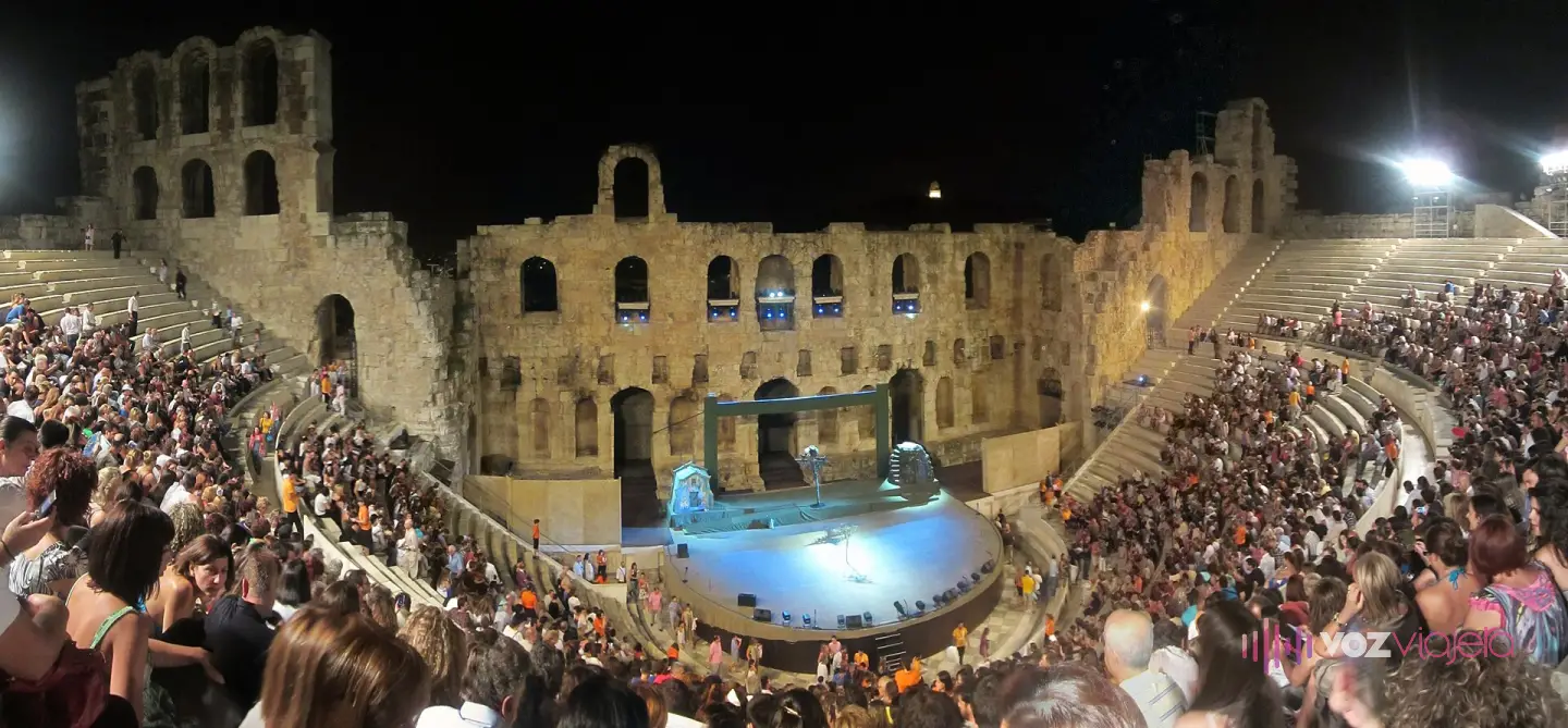 El aforo lleno en una función nocturna: el público ocupa todo el graderío y los focos montados en el muro de escena iluminan el escenario
