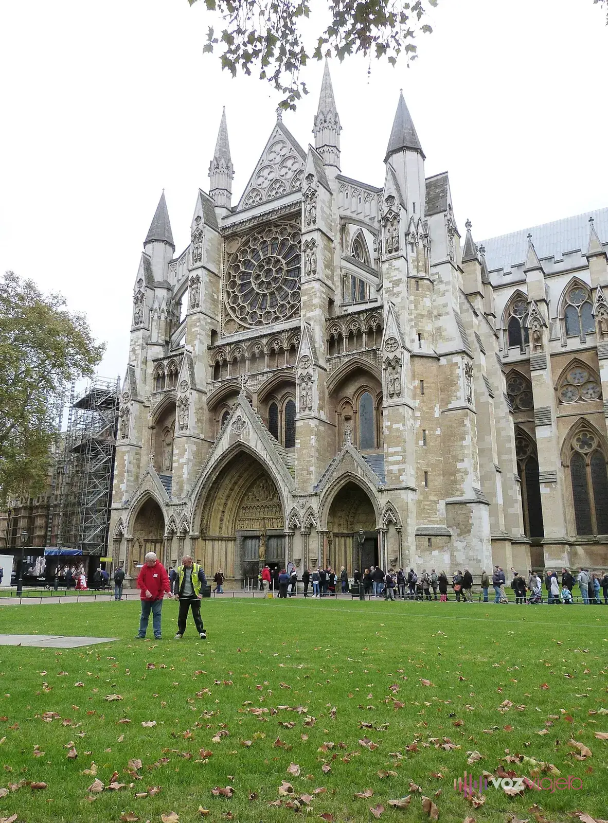 Fachada norte de la abadía de Westminster con su rosetón y la North Door, y una fila de visitantes esperando a lo largo del muro