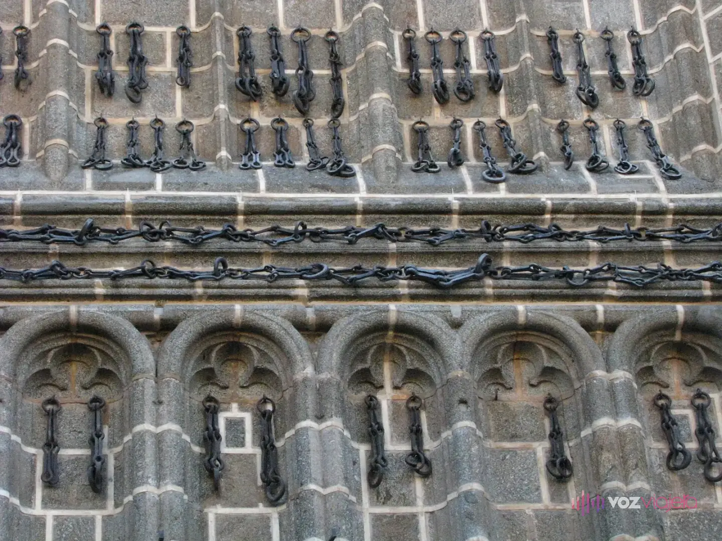 Las cadenas de hierro colgadas en el muro de granito de la iglesia de San Juan de los Reyes, en hileras horizontales y verticales