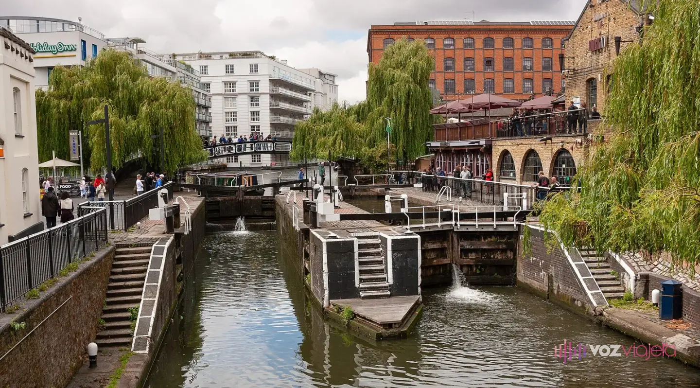 Las esclusas dobles de Camden Lock en el Regent's Canal vistas desde el puente, con sauces y edificios de ladrillo
