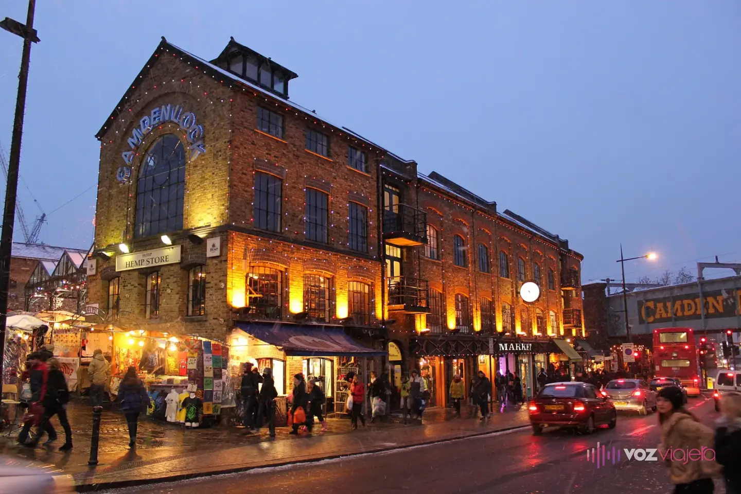 Edificio de ladrillo del Market Hall de Camden Lock iluminado al atardecer, con tiendas en la planta baja