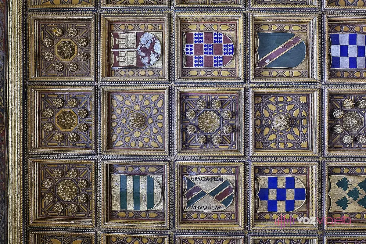 Artesonado de casetones del Salón del Pretorio en la Casa de Pilatos: casetones cuadrados dorados con lacería y escudos heráldicos de colores en las calles centrales
