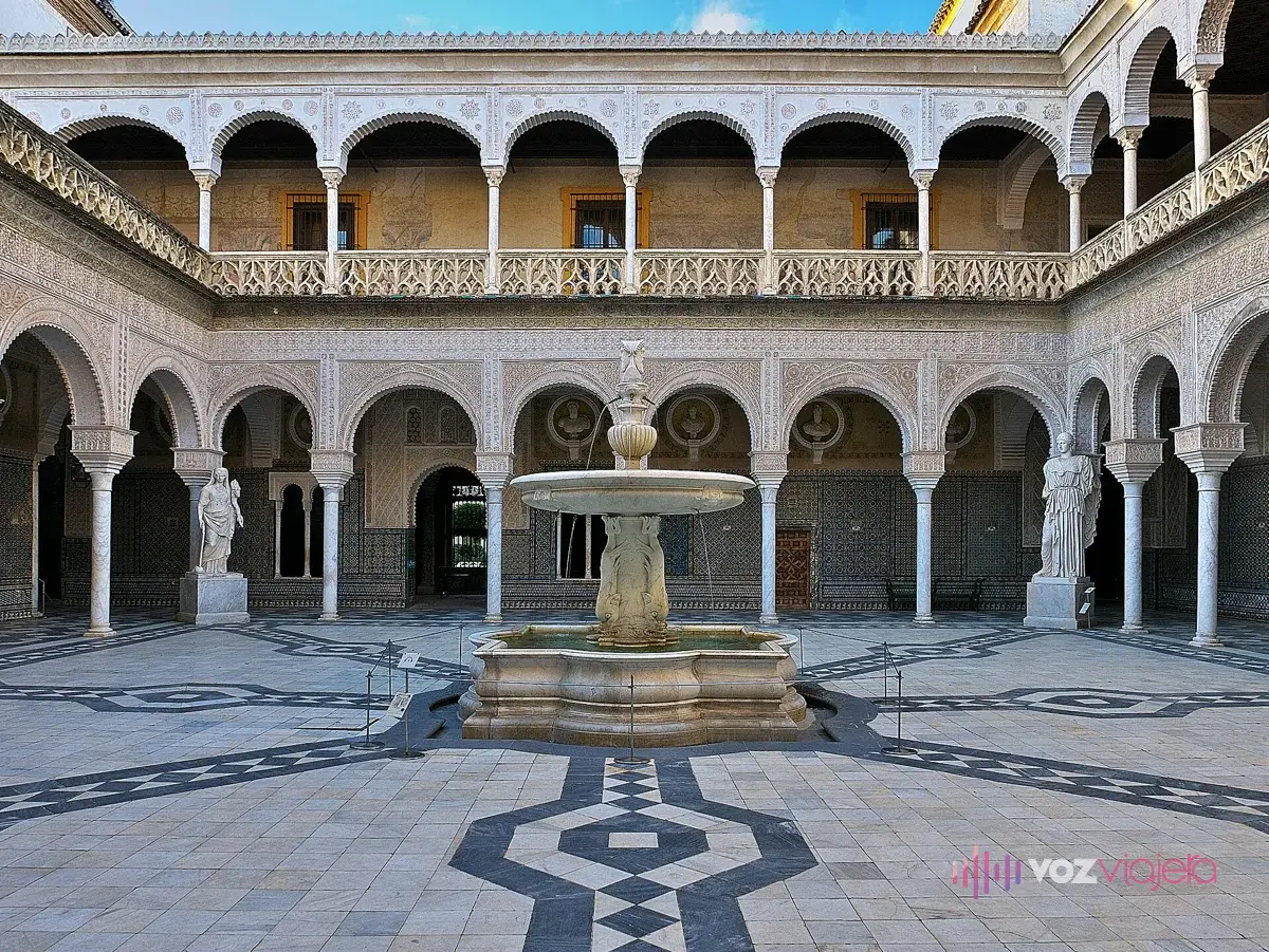 Patio principal de la Casa de Pilatos: la fuente de mármol de planta ochavada en el centro, el suelo de mármol blanco y negro, 2 estatuas clásicas en las esquinas y las galerías de arcos con yeserías en 2 plantas
