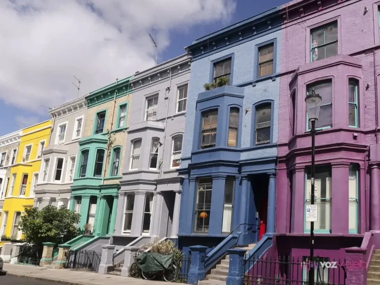 Casas victorianas adosadas de Lancaster Road pintadas de amarillo, verde, gris, azul y morado, con ventanales salientes y una farola negra