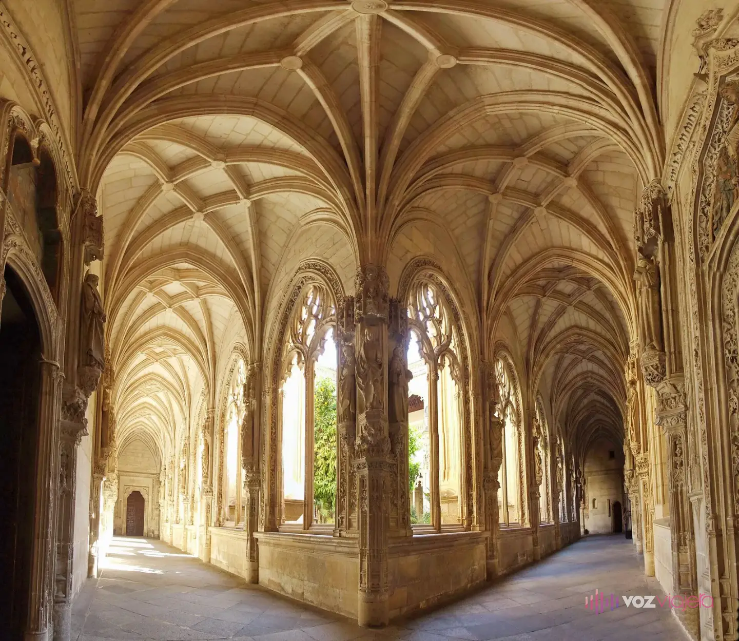 Una galería del claustro bajo de San Juan de los Reyes, con las bóvedas de crucería y los ventanales góticos calados que dan al jardín