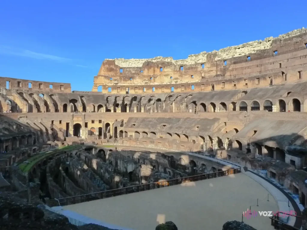 Interior del Coliseo: el tramo de suelo de arena reconstruido en un extremo, los muros de los subterráneos al descubierto en el centro y las gradas detrás