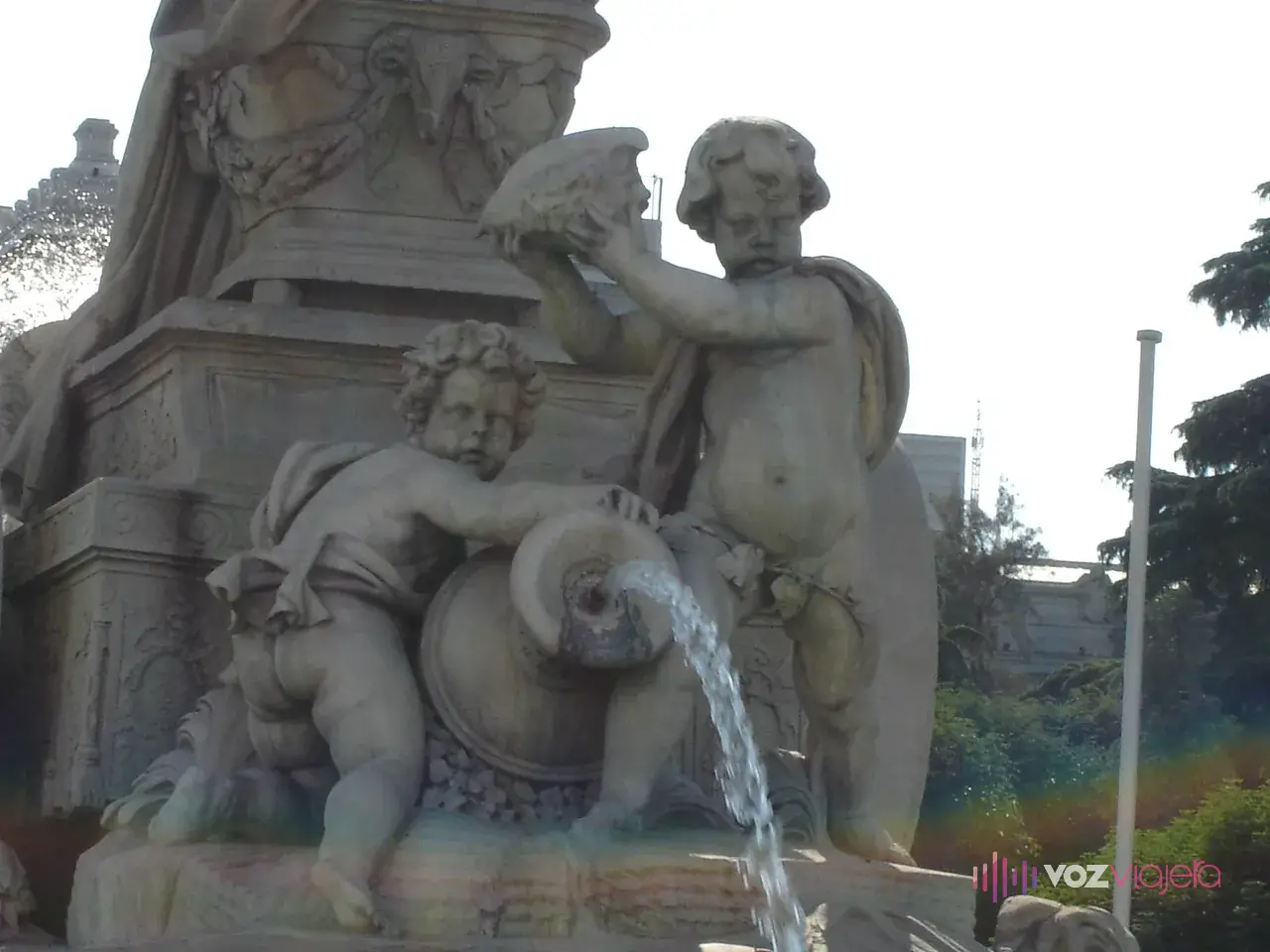 Los 2 niños de mármol de la parte trasera de la Fuente de Cibeles: uno arrodillado con un ánfora de la que sale agua y otro de pie que levanta una caracola
