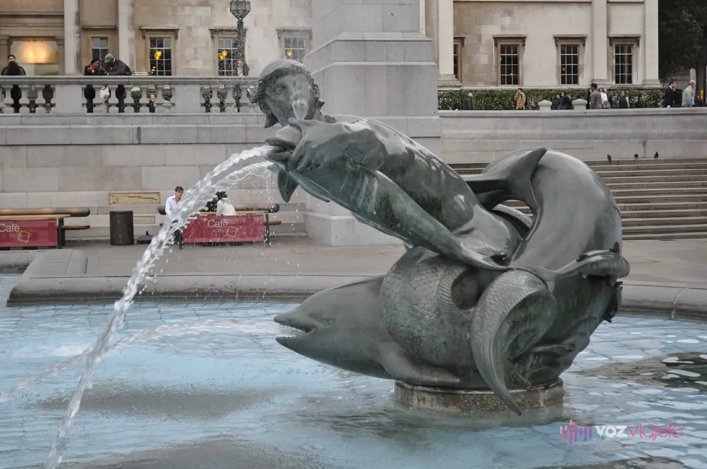 Escultura de bronce de un tritón con un delfín en el estanque de una de las fuentes, echando un chorro de agua