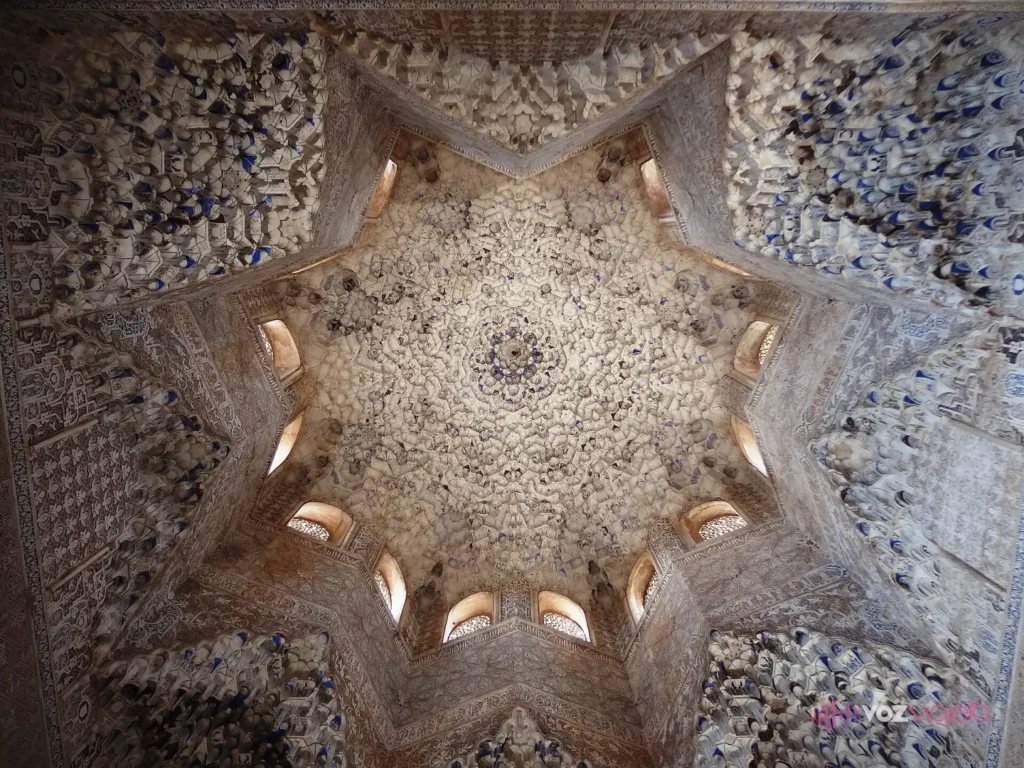 La cúpula de mocárabes de la Sala de los Abencerrajes vista desde abajo: una estrella de 8 puntas de yesería labrada con ventanas pequeñas en la base