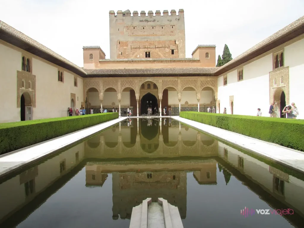 El Patio de los Arrayanes de la Alhambra: un estanque alargado entre 2 setos de arrayán que refleja el pórtico de arcos y la Torre de Comares al fondo