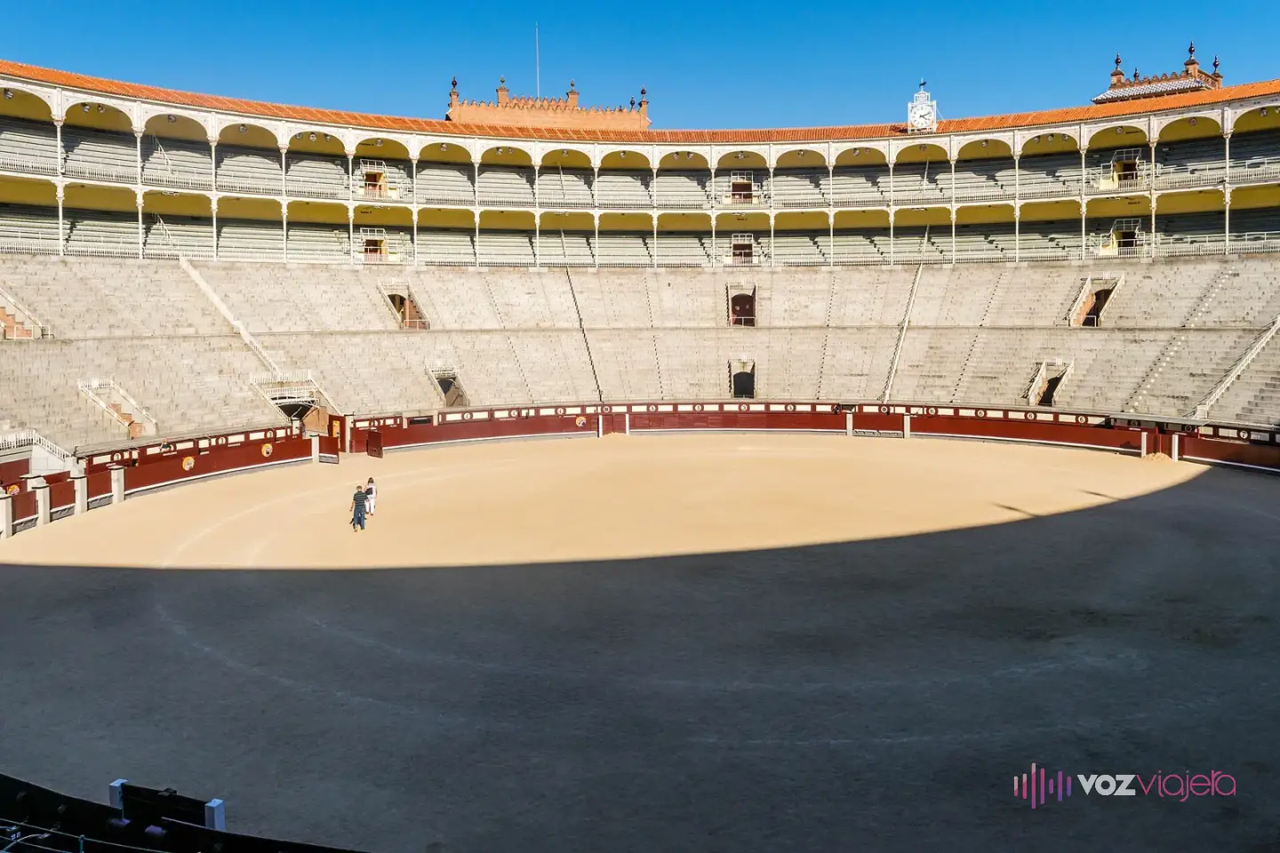 Interior vacío de Las Ventas: el ruedo de arena, la barrera roja y los tendidos de piedra bajo las gradas con arcos