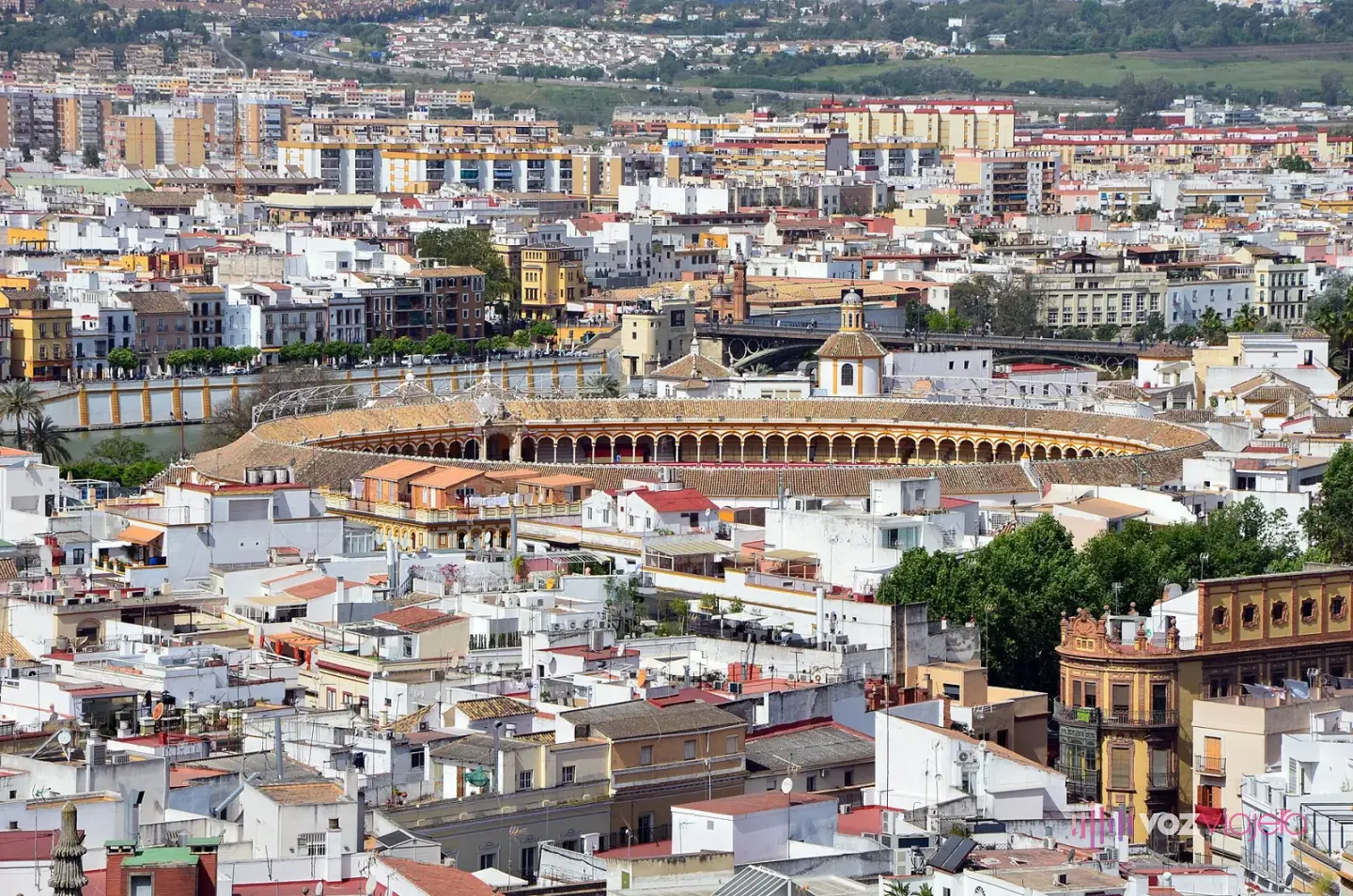 Vista de Sevilla desde lo alto de la Giralda, con la plaza de toros de la Maestranza en el centro entre los tejados y Triana al fondo