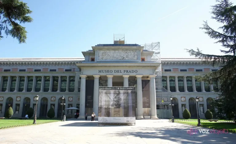 Fachada principal del edificio Villanueva del Museo del Prado, con el pórtico de columnas de la Puerta de Velázquez, el rótulo MUSEO DEL PRADO y un andamio de obras delante