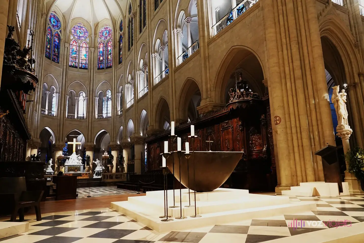 El coro de Notre Dame con el altar de bronce sobre una tarima clara, las sillerías de madera y las vidrieras del ábside al fondo