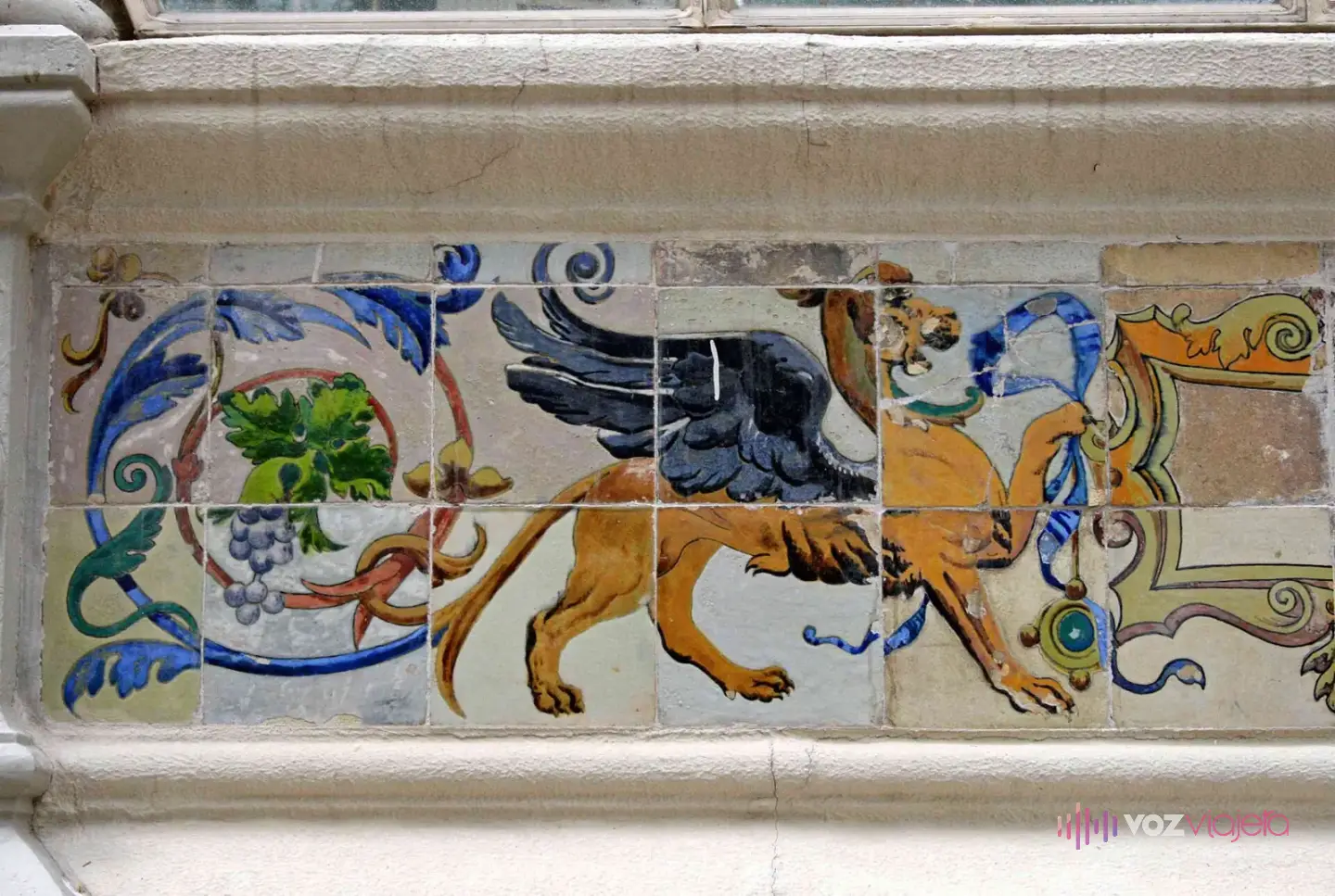 Friso de azulejos de colores en la base del Palacio de Cristal con un grifo alado entre racimos de uvas y roleos azules