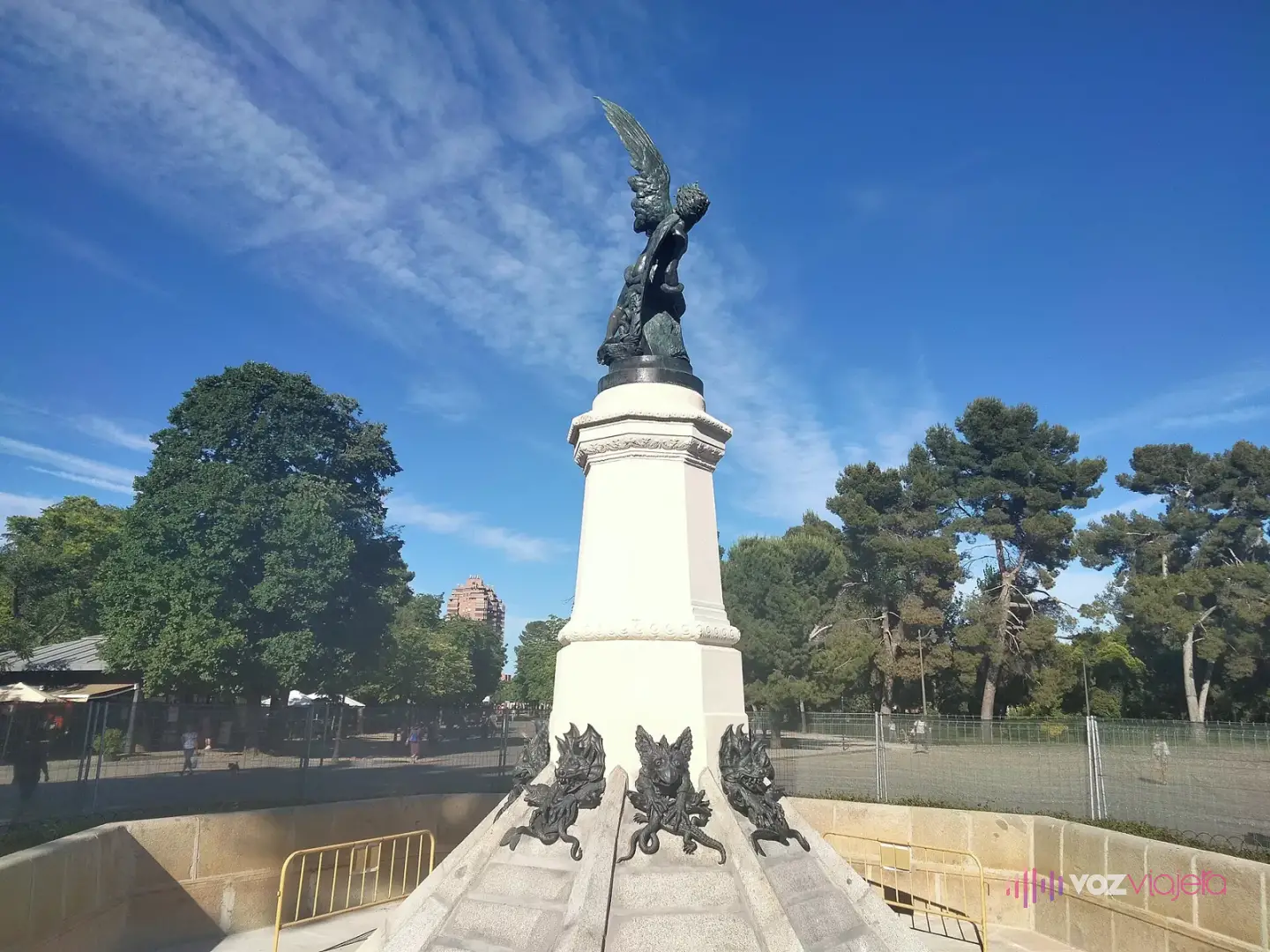 La fuente del Ángel Caído en el Retiro: la escultura de bronce del ángel expulsado del Paraíso sobre un pedestal blanco, con figuras de demonios de bronce en la base