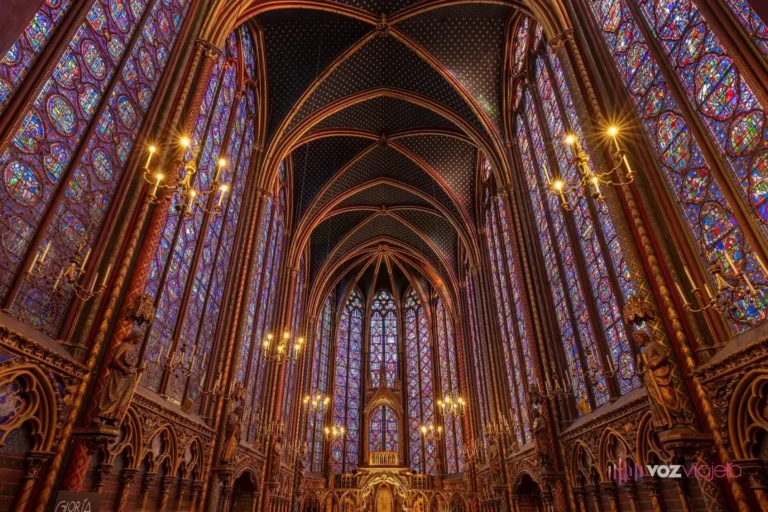 Interior de la capilla alta de la Sainte-Chapelle: muros de vidrieras azules y rojas hasta la bóveda, columnas doradas y el ábside al fondo