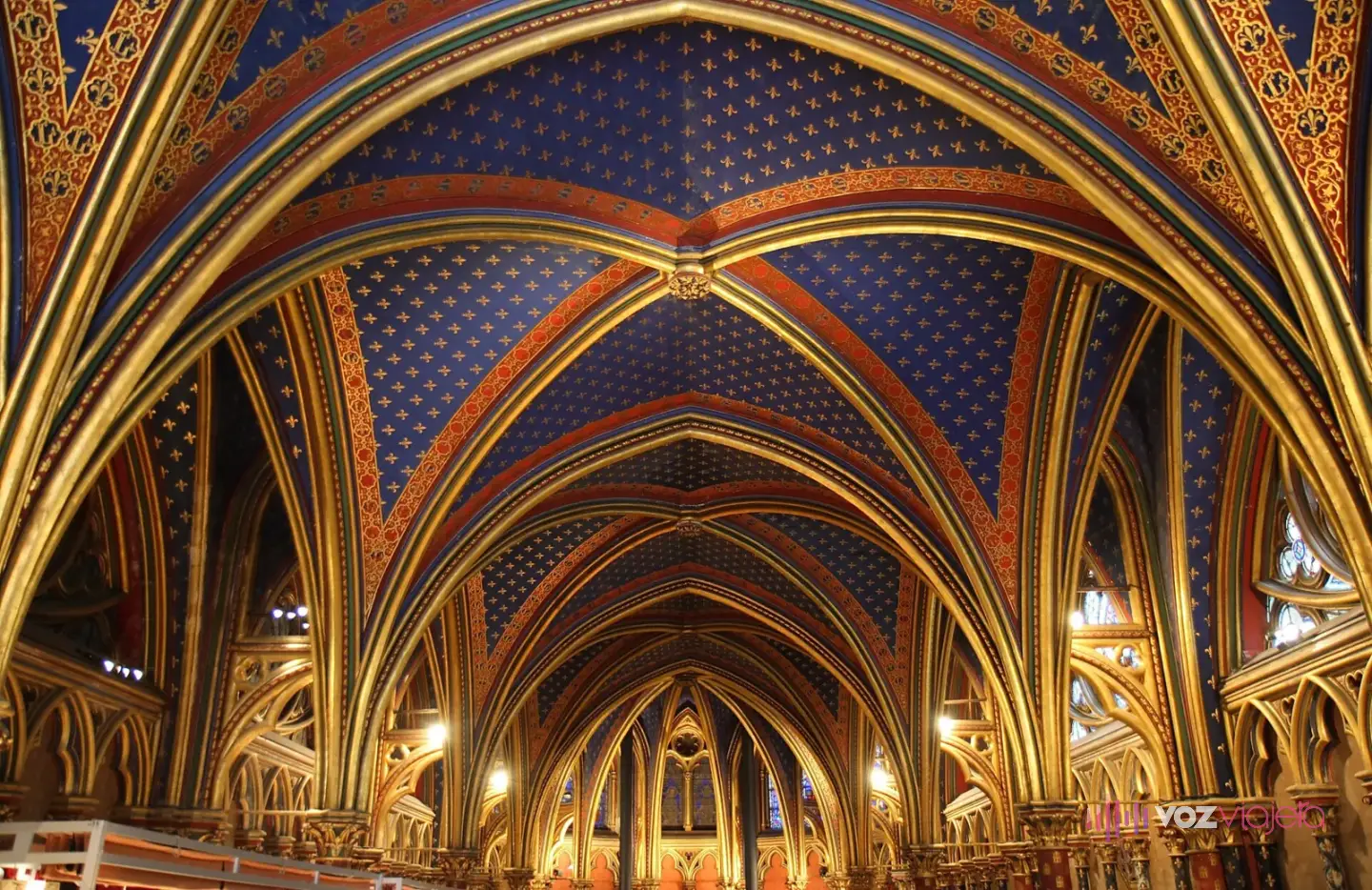 La capilla baja de la Sainte-Chapelle, con bóvedas azules sembradas de flores de lis doradas y arcos pintados en rojo y oro
