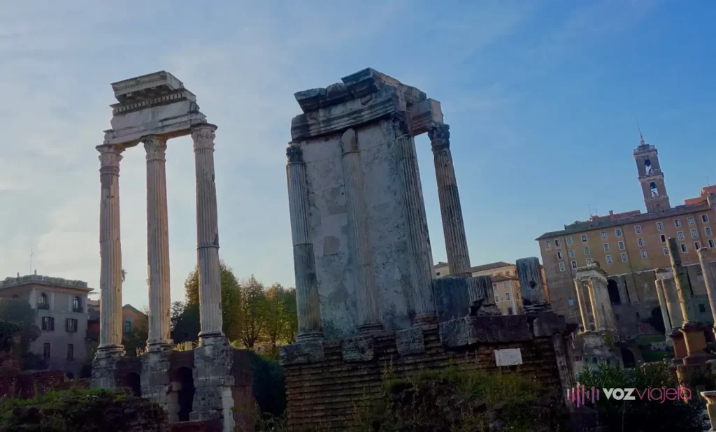 Las 3 columnas corintias del Templo de Cástor y Pólux a la izquierda y, en el centro, el fragmento reconstruido del Templo de Vesta sobre su base de ladrillo, con el Palacio Senatorio del Capitolio y su torre al fondo a la derecha